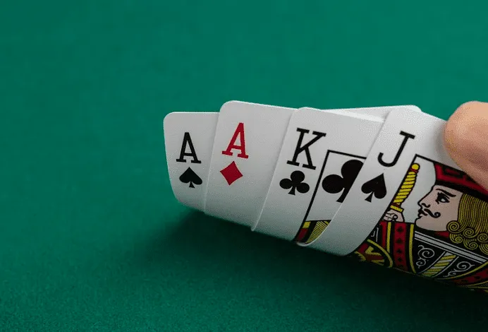 Poker table with four hole cards dealt to each player in Pot Limit Omaha